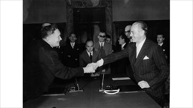 Handschlag des Bundesarbeitsministers Anton Storch (links) und des italienischen Außenministers Gaetano Martino (rechts) nach der Unterzeichnung der „Vereinbarungen über die Anwerbung und Vermittlungen von italienischen Arbeitskräften nach der Bundesrepublik Deutschland“ in Rom, 21. Dezember 1955.